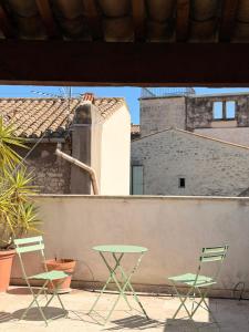 two chairs and a table on top of a building at Les chambres de Pierre in Arles