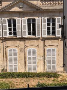 an old building with white windows and shutters at Les chambres de Pierre in Arles +43 photos