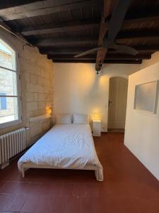 a bedroom with a white bed in a room at Les chambres de Pierre in Arles
