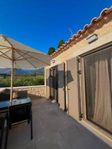 a patio with a table and an umbrella at Bella Villa in Proástion