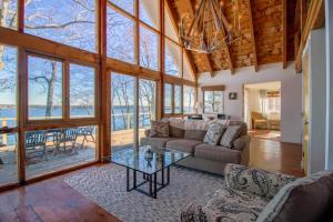 a living room with a couch and a glass table at Remodeled Waterfront Home with Wraparound Deck, Water Views, & Beach Access in Waldoboro
