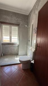 a bathroom with a toilet and a glass shower at Habita Avenida 9 Abril in Estremoz +5 photos
