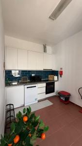 a kitchen with white cabinets and oranges in it at Habita Avenida 9 Abril in Estremoz