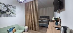 a living room with a couch and a table with a television at Rooms Lami in Dubrovnik