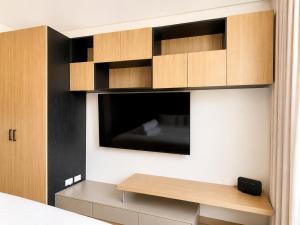 a room with a wall with a tv and a shelf at Apartaestudio Centro Internacional UTEK in Bogotá