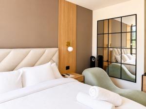 a bedroom with a white bed and a mirror at Apartaestudio Centro Internacional UTEK in Bogotá