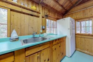 a kitchen with a sink and a white refrigerator at Waterfront cabin with ocean view & private dock in East Boothbay