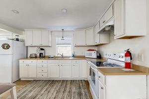 a kitchen with white cabinets and a white refrigerator at Well-located, dog-friendly home - walk to footbridge & Barrett Park in Boothbay Harbor +7 photos