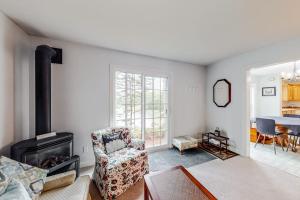 a living room with a chair and a fireplace at Idyllic waterfront home with furnished deck, grill, sweeping views & private W/D in Waldoboro