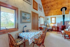 a dining room with a table and chairs and a wooden ceiling at Beautiful hilltop home with deck & view of Penobscot Bay - near festivals & more in Rockport