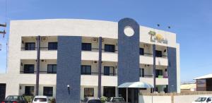 a building with a largeolith in front of it at Tropical Praia Hotel in Aracaju