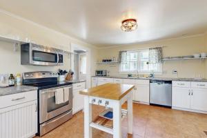 a kitchen with white appliances and a wooden table at Beautiful Retreat | Home Office | Walk 5 MInutes to Main Street in Wiscasset +17 photos