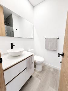 a white bathroom with a sink and a toilet at Apartaestudio Centro Internacional UTEK in Bogotá