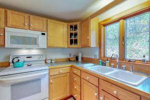 a kitchen with a sink and a microwave at Beautiful hilltop home with deck & view of Penobscot Bay - near festivals & more in Rockport