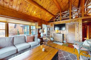a living room with a couch and a table at Riverfront retreat with a furnished deck, washer/dryer & fast WiFi in Boothbay