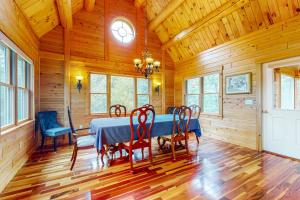 a dining room with a blue table and chairs at Tranquil Haven | Secluded waterfront house with sauna, dock, kayaks, canoe, gym in Greenville +25 photos