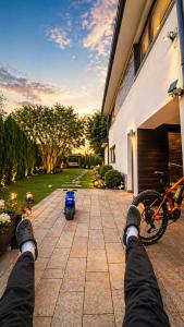 a person with their feet up on a house with a bike at Lux Villa Waldenburg in Wałbrzych