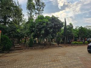 a parking lot with trees in a park at Rose Petals in Sagana