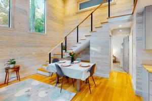a dining room with a table and a staircase at Contemporary retreat with grill, firepit, & patio - walk to beach in Marlboro