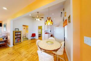 a dining room with a table and white chairs at Waterfront home on St George River with private beach & deck - near festivals in Cushing