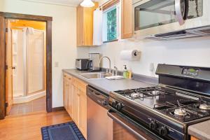 a kitchen with a stove and a sink at Woodland Home near Long Pond w/ Spacious Living Area, Full Kitchen & Deck in Somesville