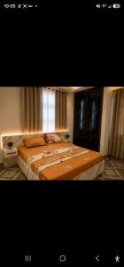 a bedroom with a large bed and a window at Edmundson Villa Apartment in Ejisu