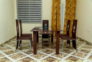 a dining room with a table and two chairs at Edmundson Villa Apartment in Ejisu +13 photos