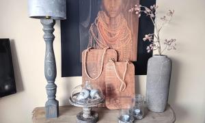 a table with a lamp and a picture of a woman at Vechtdalchalet, De Wilg in Rheezerveen