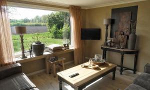 a living room with a table and a window at Vechtdalchalet, De Wilg in Rheezerveen