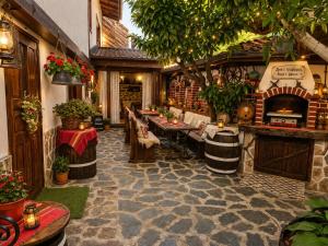 a restaurant with tables and chairs and a fireplace at Къща за гости Плевнята in Bansko