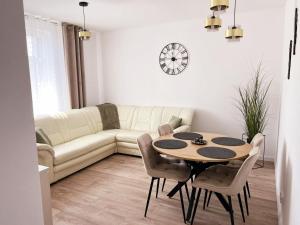 a living room with a table and a couch at Apartament Storczykowy in Frombork +4 photos