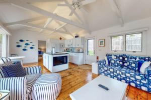 a living room with a couch and a table at Oceanfront Cottage & Studio on Mill Cove w/ Water Views, Deck - Walk Downtown in Boothbay Harbor
