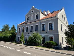 a large white house on the side of a street at Apartament Storczykowy in Frombork