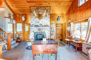 a living room with a stone fireplace and a table at Vintage lakefront cabin with incredible water views, private dock & pebble beach in The Highlands