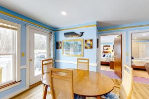 a dining room with a wooden table and blue walls at Colorful duplex home with a large yard, deck, WiFi, & ideal Midcoast location in Boothbay
