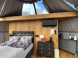 a bedroom with a bed and a tv on the wall at Lofoten Aurora Dome in Hanøya