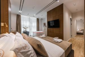 a hotel room with a large bed and a television at Via Mare Jacuzzi Suites by PS in Durrës