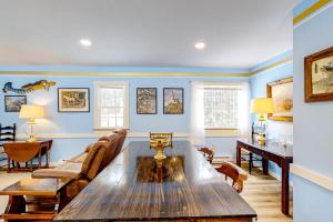 a living room with blue walls and a wooden table at Colorful duplex home with a large yard, deck, WiFi, & ideal Midcoast location in Boothbay