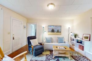 a living room with a white couch and a blue chair at Cozy apartment with harbor view - full kitchen & washer/dryer - walk to water in Rockport