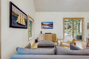 a living room with a couch and a table at Charming New Home with Hot Tub, Spacious Deck, Gas Grill, WiFi, and Washer/Dryer in Boothbay