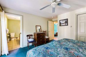 a bedroom with a bed and a ceiling fan at Charming cottage near the beach with balcony, deck, grill, fireplace - dogs OK in Georgetown +15 photos