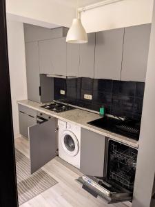 a white kitchen with a washing machine in it at Bran' s in Constanţa +3 photos