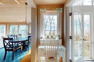 a kitchen and dining room with a table and chairs at Oceanfront retreat with sunrise views, screened porch, & deck in Blue Hill +21 photos
