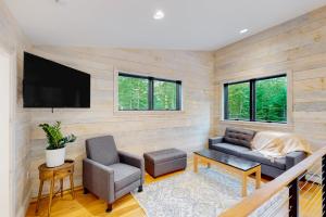a living room with a couch and a tv at Contemporary retreat with grill, firepit, & patio - walk to beach in Marlboro