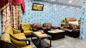 a living room with couches and chairs and a table at The Al-Maaz Guest House in Murree