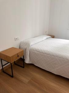 ein Schlafzimmer mit einem Bett und einem Holztisch in der Unterkunft Dakar in Sarria