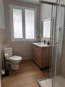 ein Badezimmer mit Toilette, Waschbecken und zwei Fenstern in der Unterkunft Dakar in Sarria