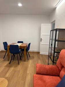 ein Esszimmer mit einem Tisch und blauen Stühlen in der Unterkunft Dakar in Sarria