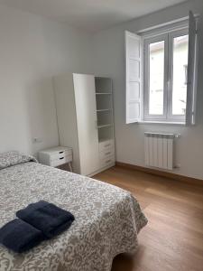 ein weißes Schlafzimmer mit einem Bett und einem Fenster in der Unterkunft Dakar in Sarria