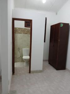 a bathroom with a toilet and a brown cabinet at The Emerald Ceylon - Colombo in Pannipitiya +2 photos
